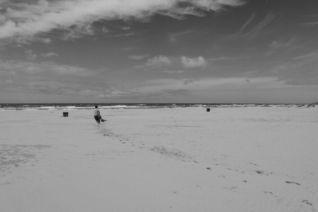 Strand van Schoorl man en kind spelen (ver weg), zwart wit