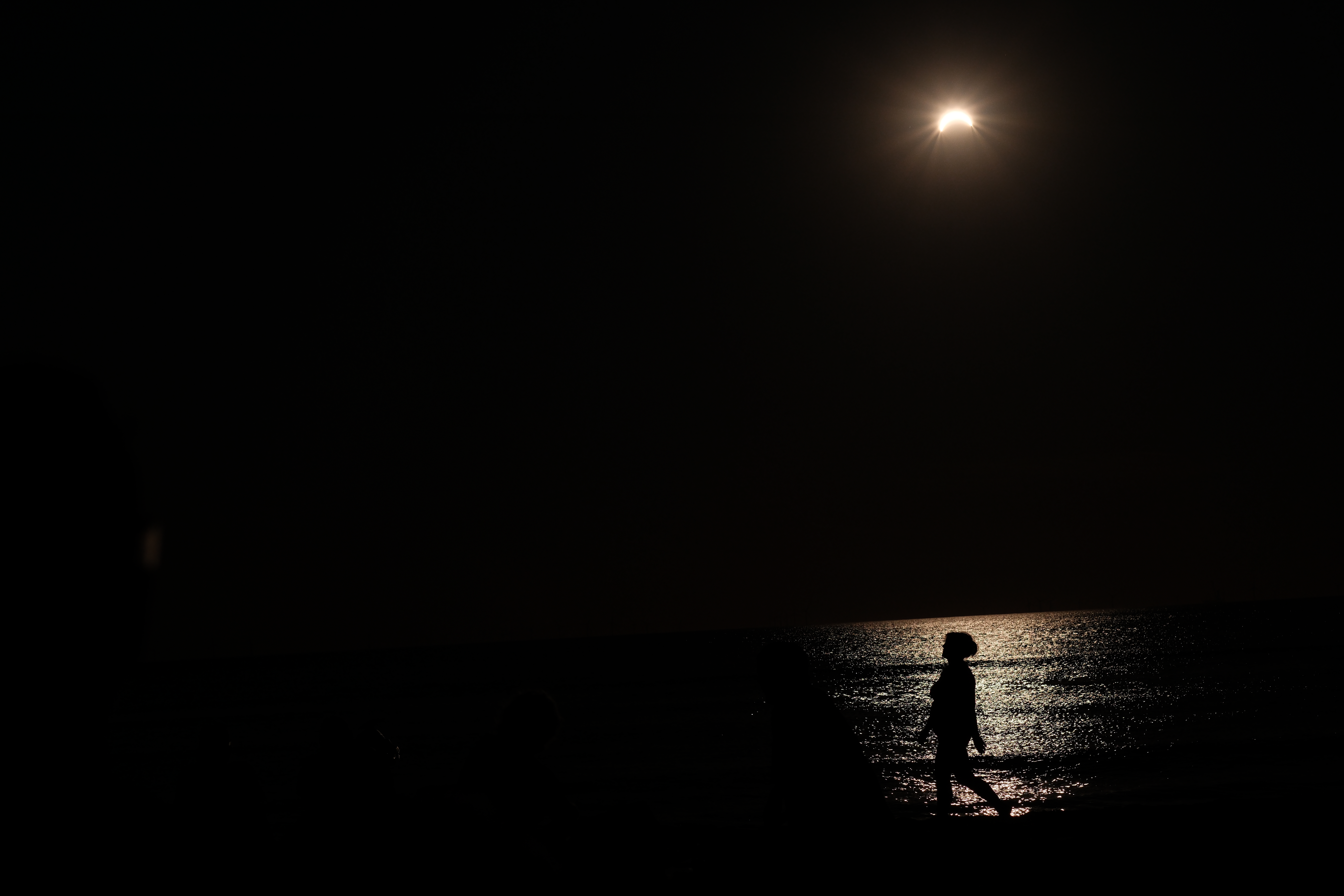 zonsverduistering  schaduw aan het strand een vrouw