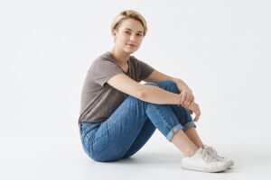 fotomodel zit op grond tegen witte achtergrond